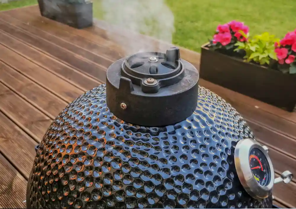 Dym unoszący się z otworu w grillu ceramicznym kamado.